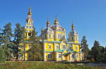 Almaty for Tourists - The colorful Ascension Cathedral in Almaty, a stunning wooden architectural masterpiece surrounded by greenery and blue skies.