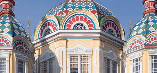 Close-up view of the colorful domes of Zenkov Cathedral in Almaty, Kazakhstan, showcasing intricate geometric patterns and vibrant architectural details.