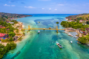 Scenic view of Nusa Ceningan in Nusa Islands Bali, showcasing the iconic yellow bridge connecting it to Nusa Lembongan, with lush greenery and azure waters.