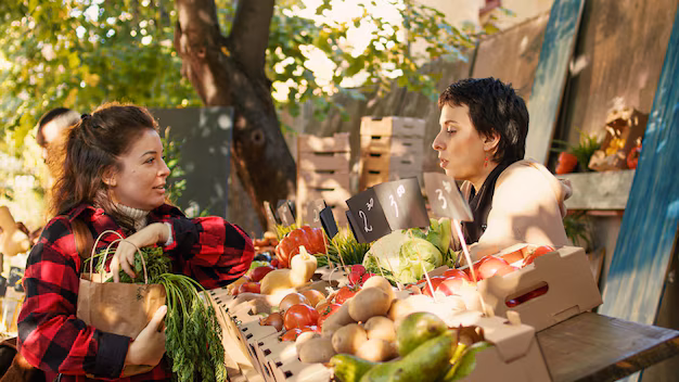a girl purchase vegetables from Green Bazaar in Almaty, showcasing vibrant market life with people shopping for fresh produce, handmade crafts, and local delicacies amidst colorful stalls and bustling activity.